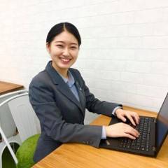 スーツを着た栄養士が笑顔でこちらを向いている