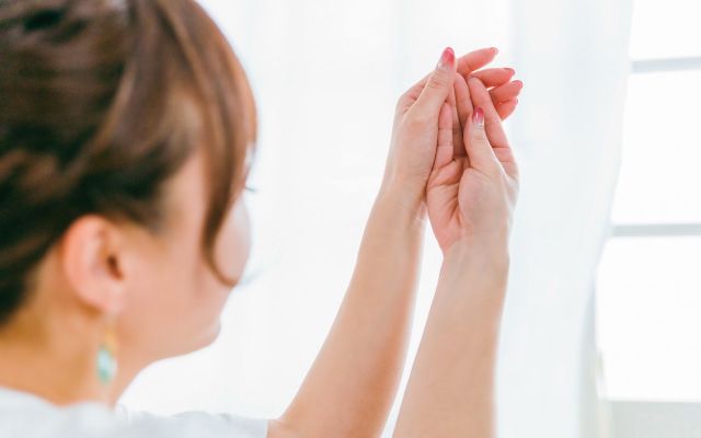 手浴をして温まった手先を見る女性