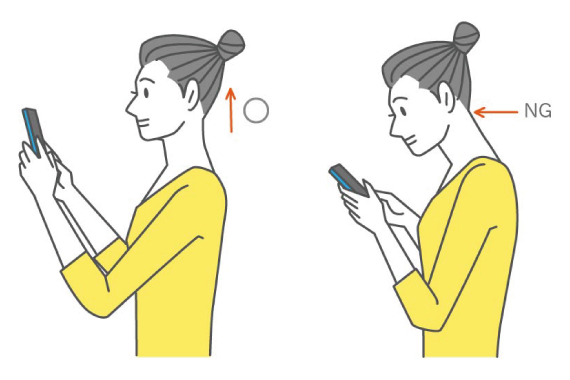 スマホを使用する際猫背になっている女性の画像