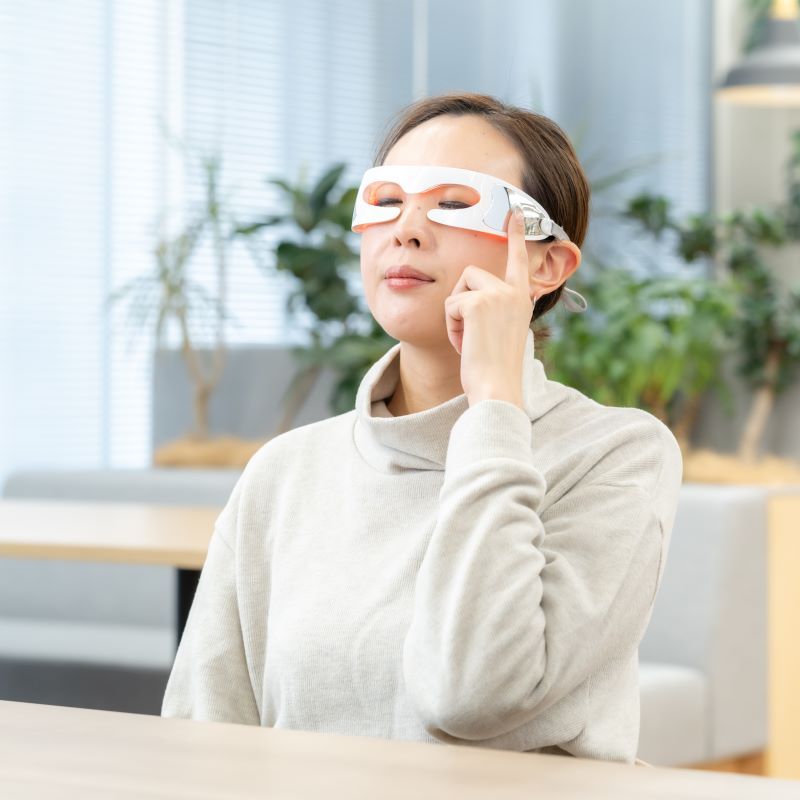 LEDアイマッサージャーを着用する女性