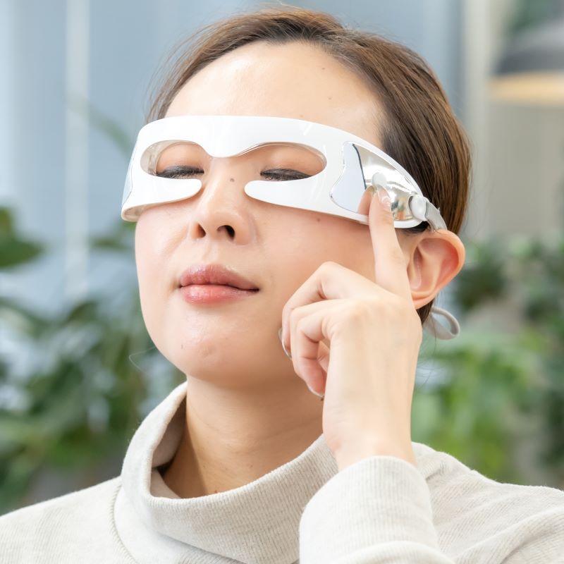 LEDアイマッサージャーを着用する女性