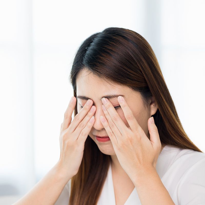 目をこする女性