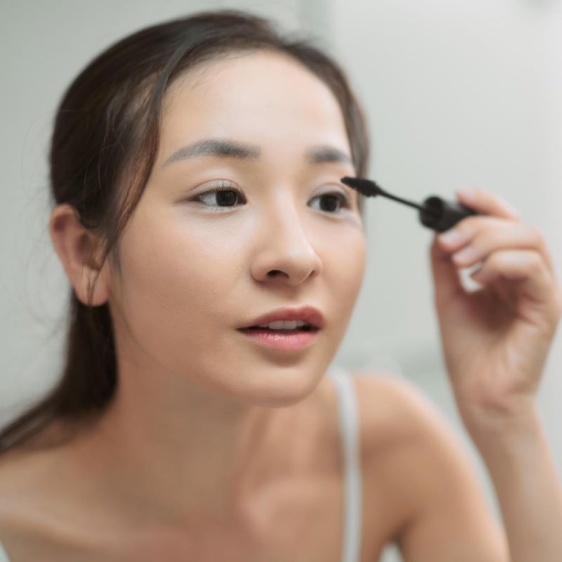 まつ毛にマスカラを塗る女性