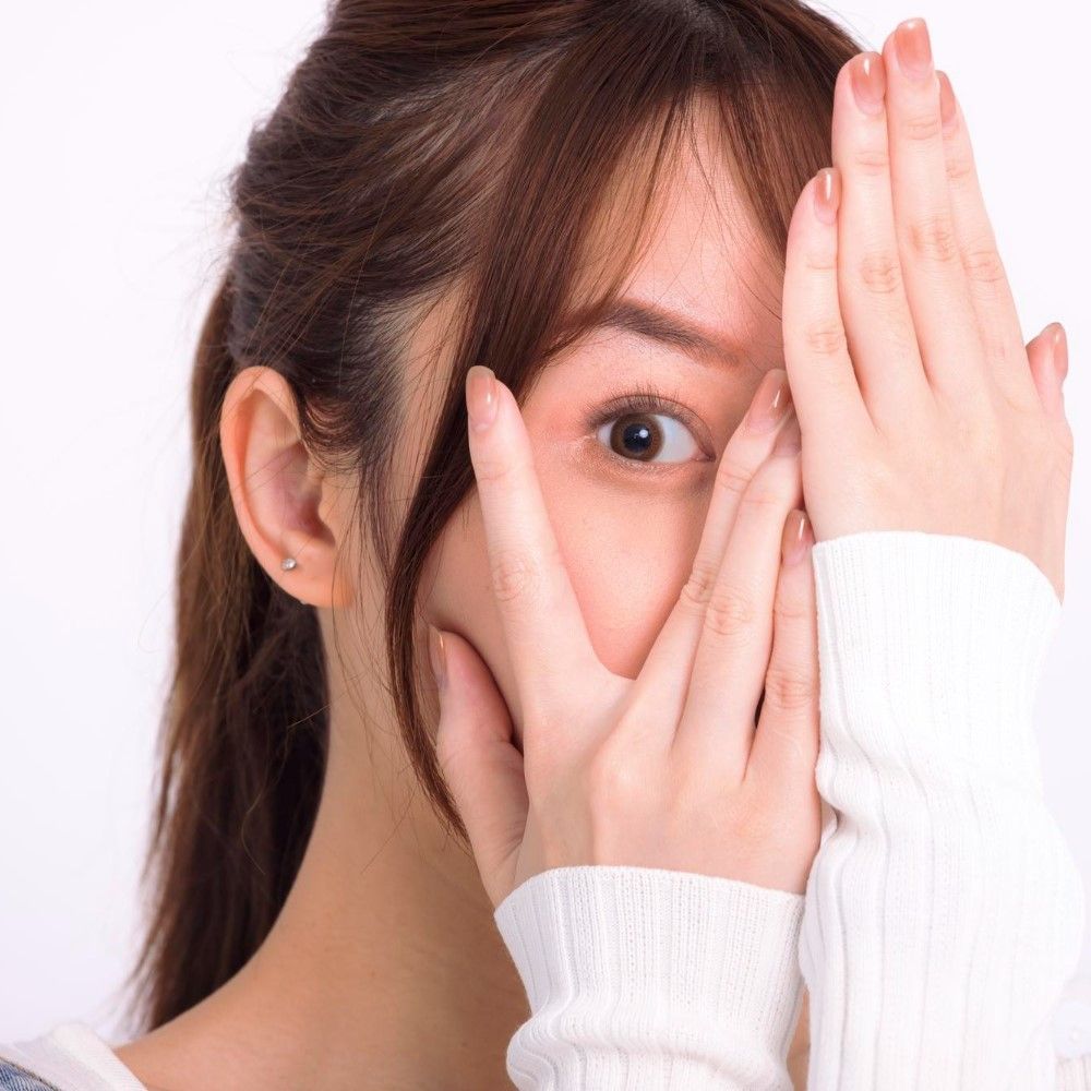 片目を手で隠す女性