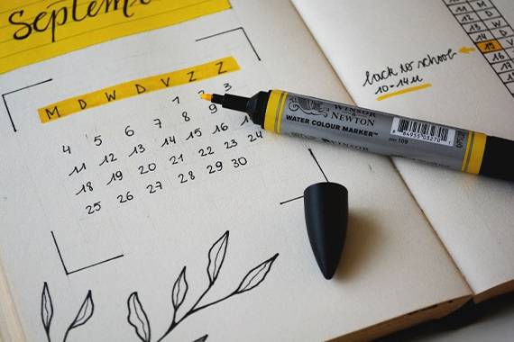 スケジュール帳と黄色のマーカーペン